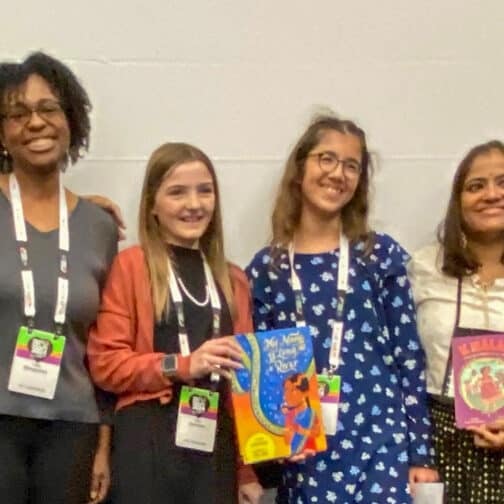 Group of six panelists and students hold up books and smile