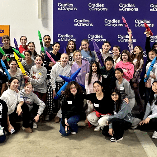 Group of students, some holding giant crayons