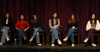 Six female-presenting students seated on stage