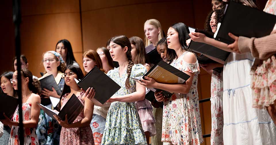 SpringConcert960x504 diverse group of girls in spring floral dresses singing on stage