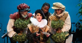 Four students on stage dressed in Renaissance costumes.