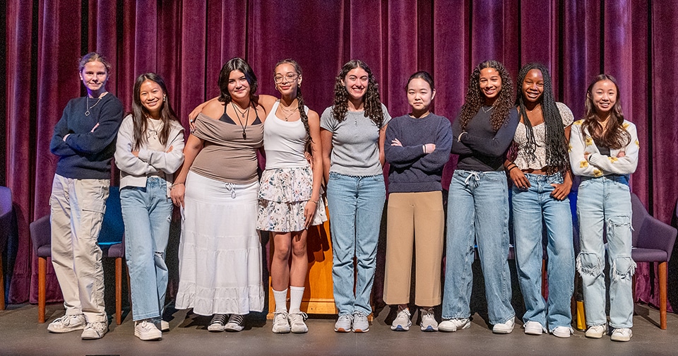 Brookspoetry_2 9 students stand shoulder to shoulder on stage
