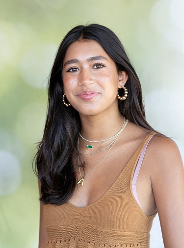 Young woman with long, dark hair and a brown tank top