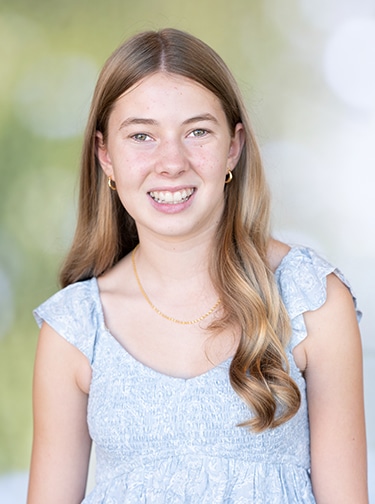 young, blonde woman in a short-sleeved blue top
