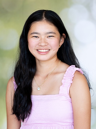 Young woman with long, dark hair and a light pink tank top