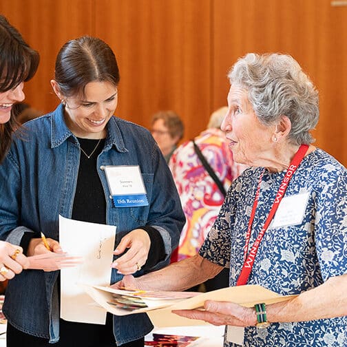 Four alums from across generations look at archival documents.