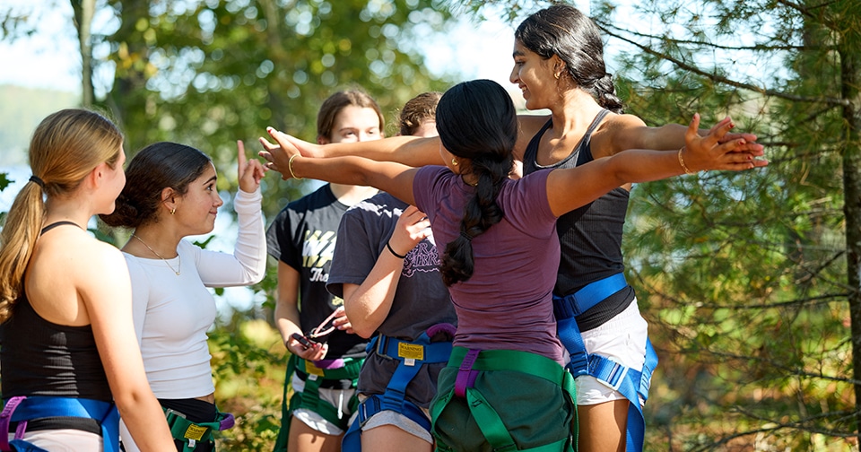 Give students wear harnesses for a ropes course activity outside