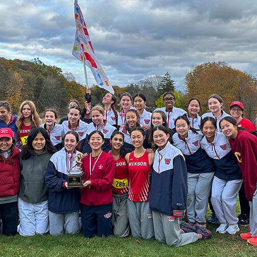 Team of athletes holds their trophy.