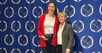 Gevvie Stone poses for a photo holding her award next to Karen Geronimi