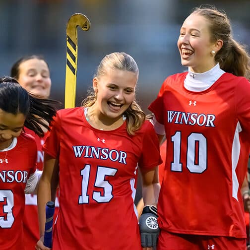 Winsor field hockey players celebrate together