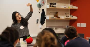 Sana Sharma gestures with hand at the front of a classroom