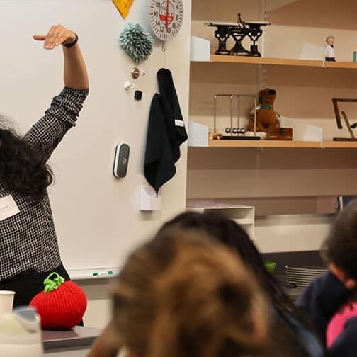 Sana Sharma gestures with hand at the front of a classroom