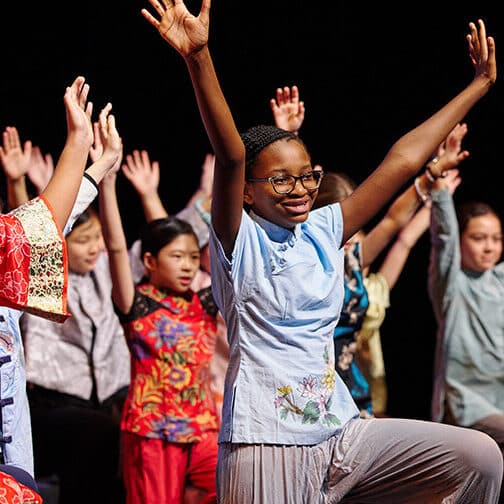 a group of student performers dancing on stage