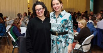 Two women posing side by side, smiling.