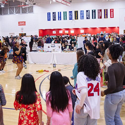 Kids in a school gym watching a dance troupe