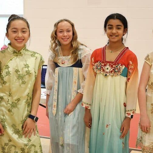 four girls in historical greek, roman, and chinese outfits