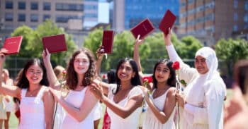 Five students hold their diplomas aloft