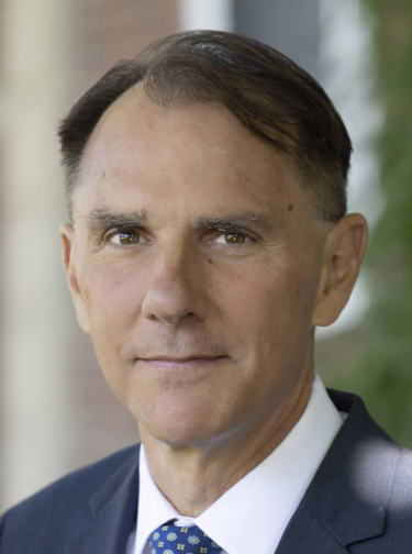Man with short dark hair wearing a suit