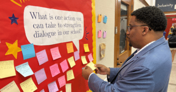 History Faculty Julian Braxton looks at sticky notes on a bulletin board