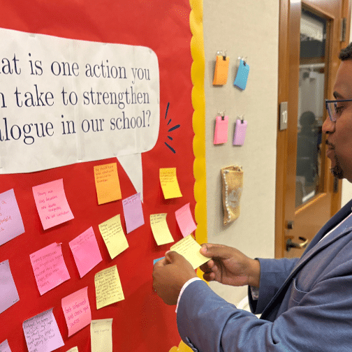 History Faculty Julian Braxton looks at sticky notes on a bulletin board