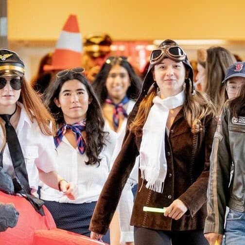 A group of students walking down the hallway in flight gear.