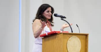 Woman stands at a podium receiving an award.