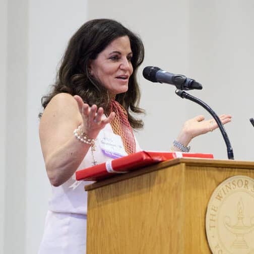 Woman stands at a podium receiving an award.