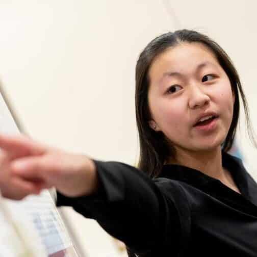 Student points at a poster.