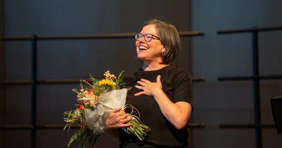 Woman holds a bouquet of flowers.